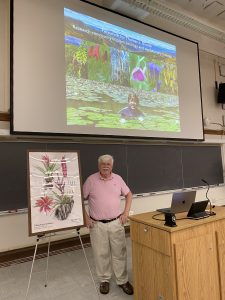 Tom Givnish stands next to the framed print of Tillandsia givnishiana