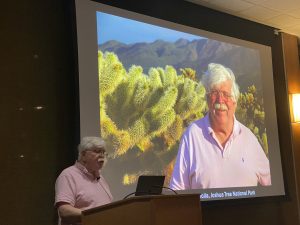 Tom Givnish stands at the lectern with a slide of himself on the screen behind him